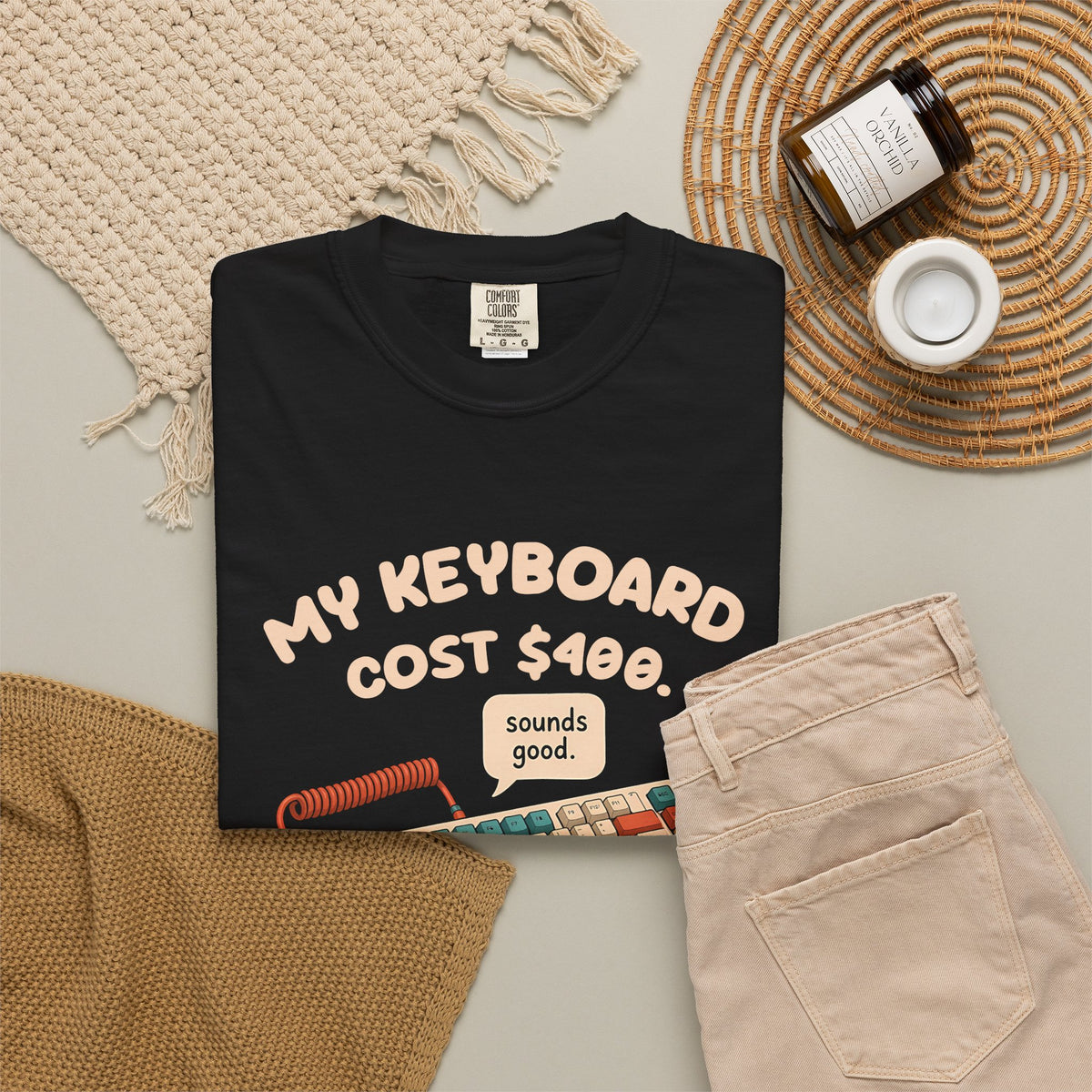 Black My Keyboard Cost $400 tee by Mildly Unavailable laid flat with folded pants and home decor