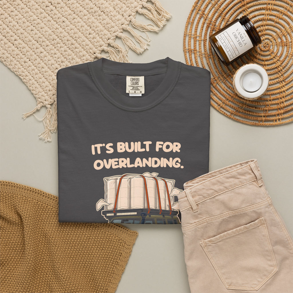 Graphite Built for Overlanding tee by Mildly Unavailable laid flat with folded pants and home decor
