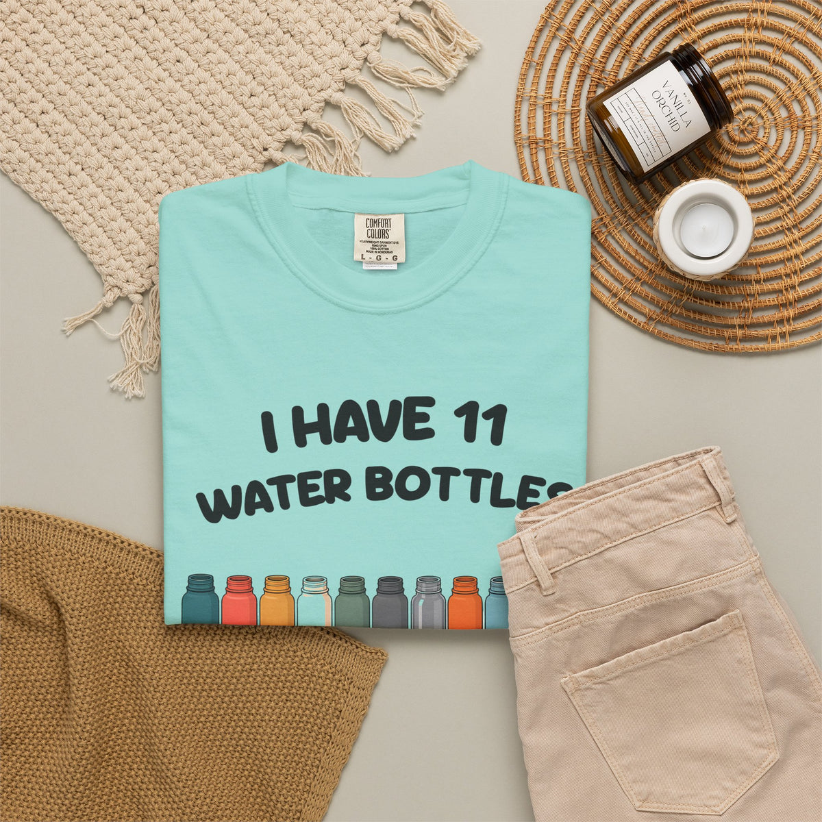 Chalky Mint 11 Water Bottles, No Lids tee by Mildly Unavailable laid flat with folded pants and home decor