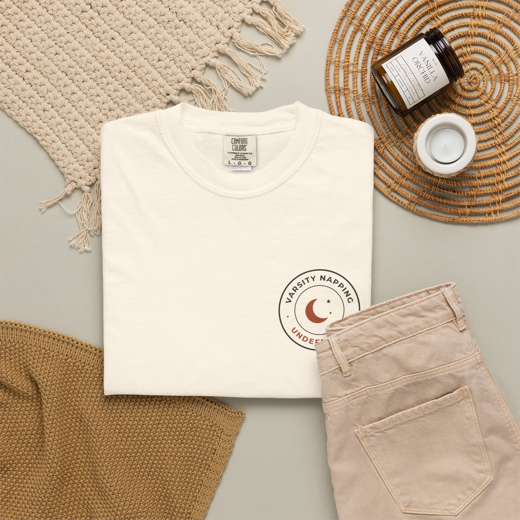 Flat-lay of the ivory Varsity Napping tee by Mildly Unavailable