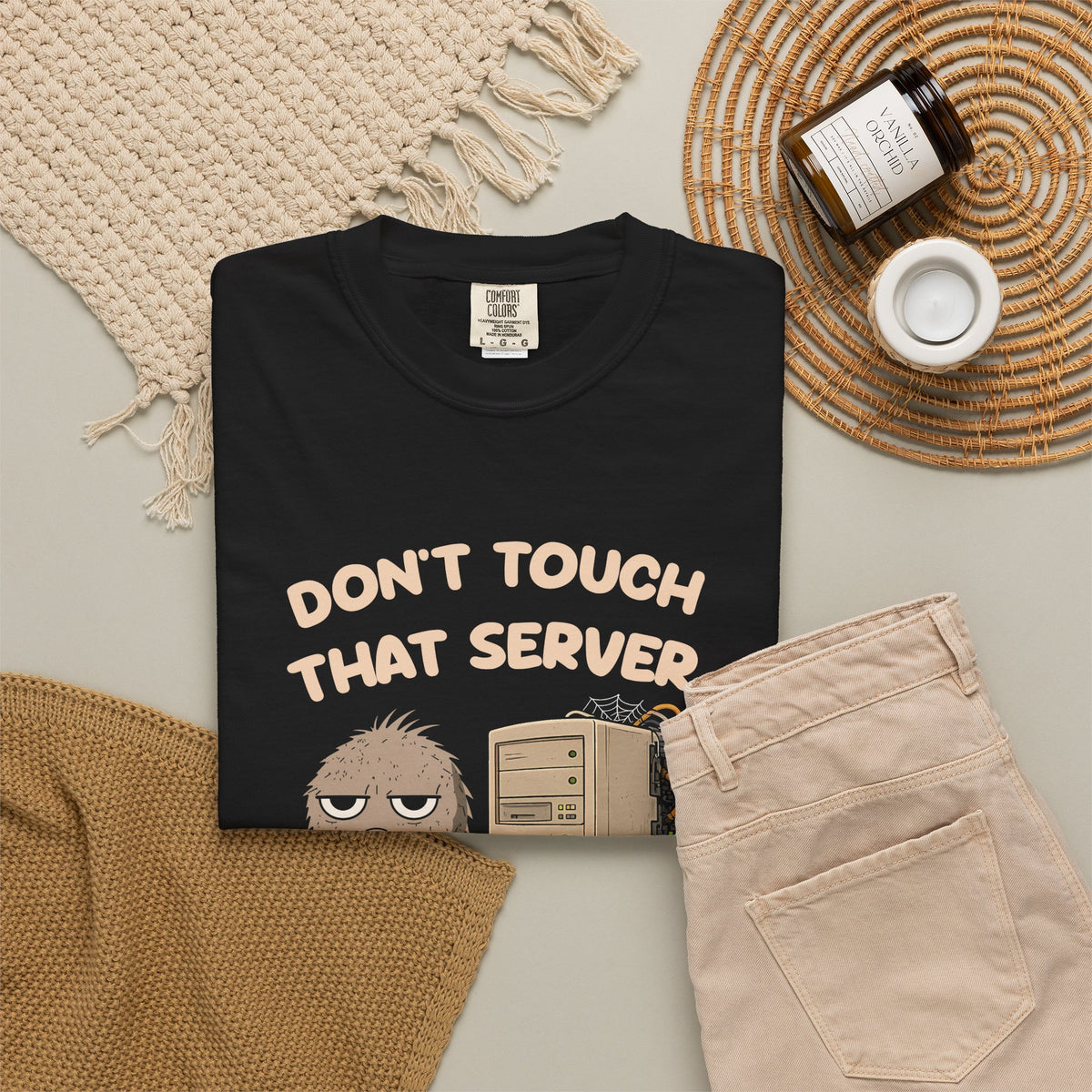 Black Don't Touch That Server Murray tee by Mildly Unavailable laid flat with folded pants and home decor