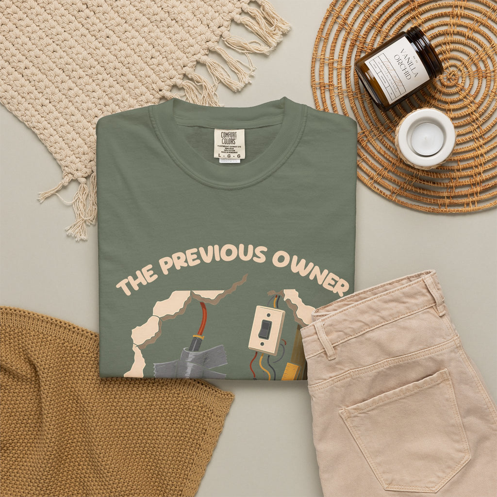 Moss The Previous Owner Did It Himself tee by Mildly Unavailable laid flat with folded pants and home decor