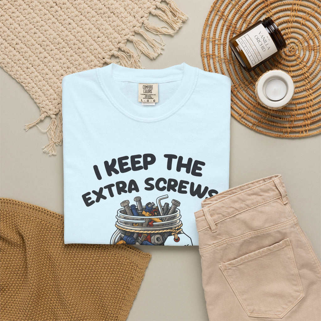 Chambray I Keep the Extra Screws tee by Mildly Unavailable laid flat with folded pants and home decor