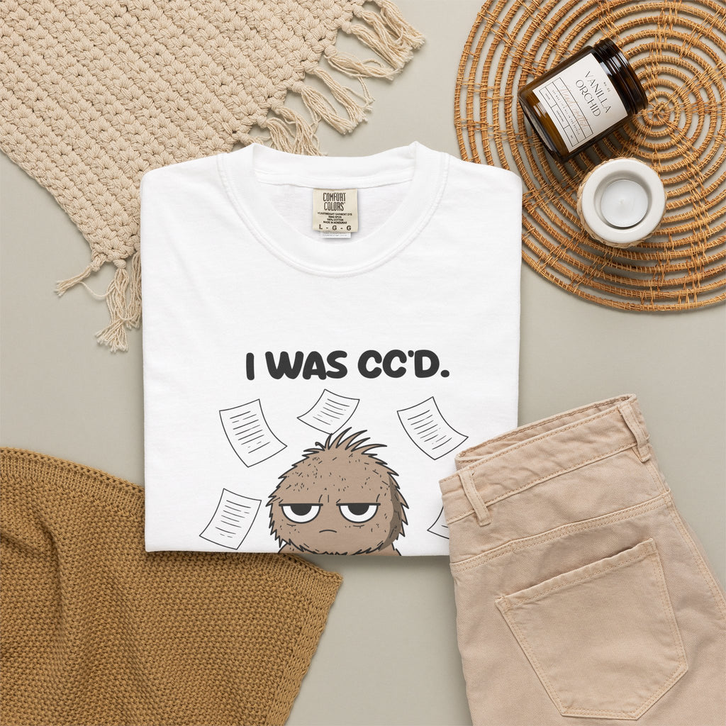White I Was CC'd Murray tee by Mildly Unavailable laid flat with folded pants and home decor