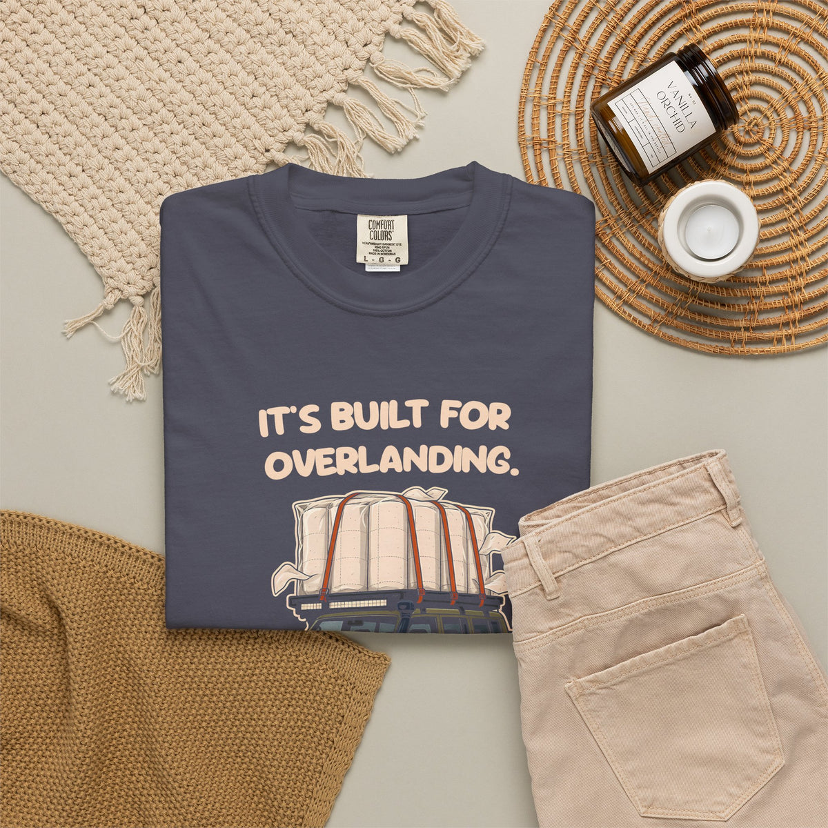 Navy Built for Overlanding tee by Mildly Unavailable laid flat with folded pants and home decor