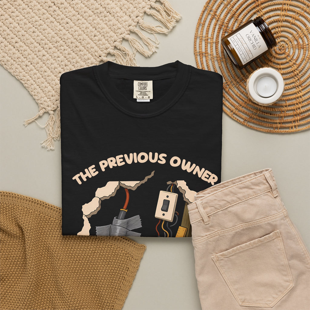 Black The Previous Owner Did It Himself tee by Mildly Unavailable laid flat with folded pants and home decor
