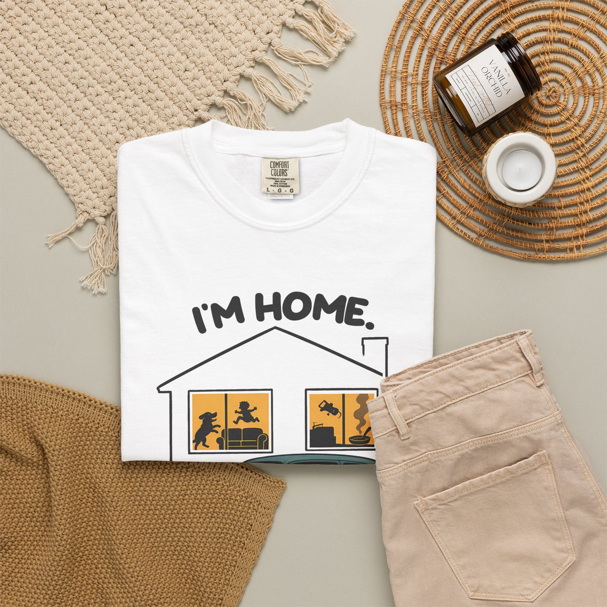 White Just Sitting in the Car for a Minute Murray tee by Mildly Unavailable laid flat with folded pants and home decor