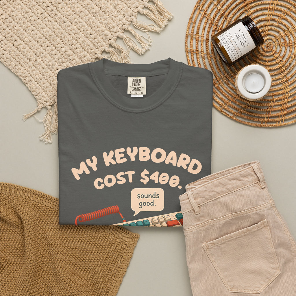 Pepper My Keyboard Cost $400 tee by Mildly Unavailable laid flat with folded pants and home decor