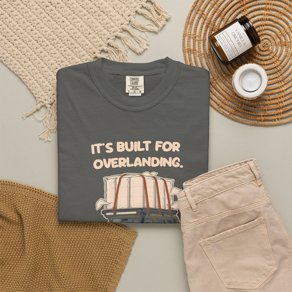 Pepper Built for Overlanding tee by Mildly Unavailable laid flat with folded pants and home decor