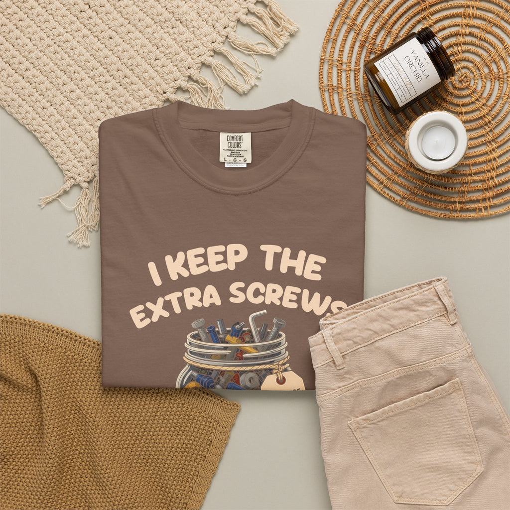 Espresso I Keep the Extra Screws tee by Mildly Unavailable laid flat with folded pants and home decor