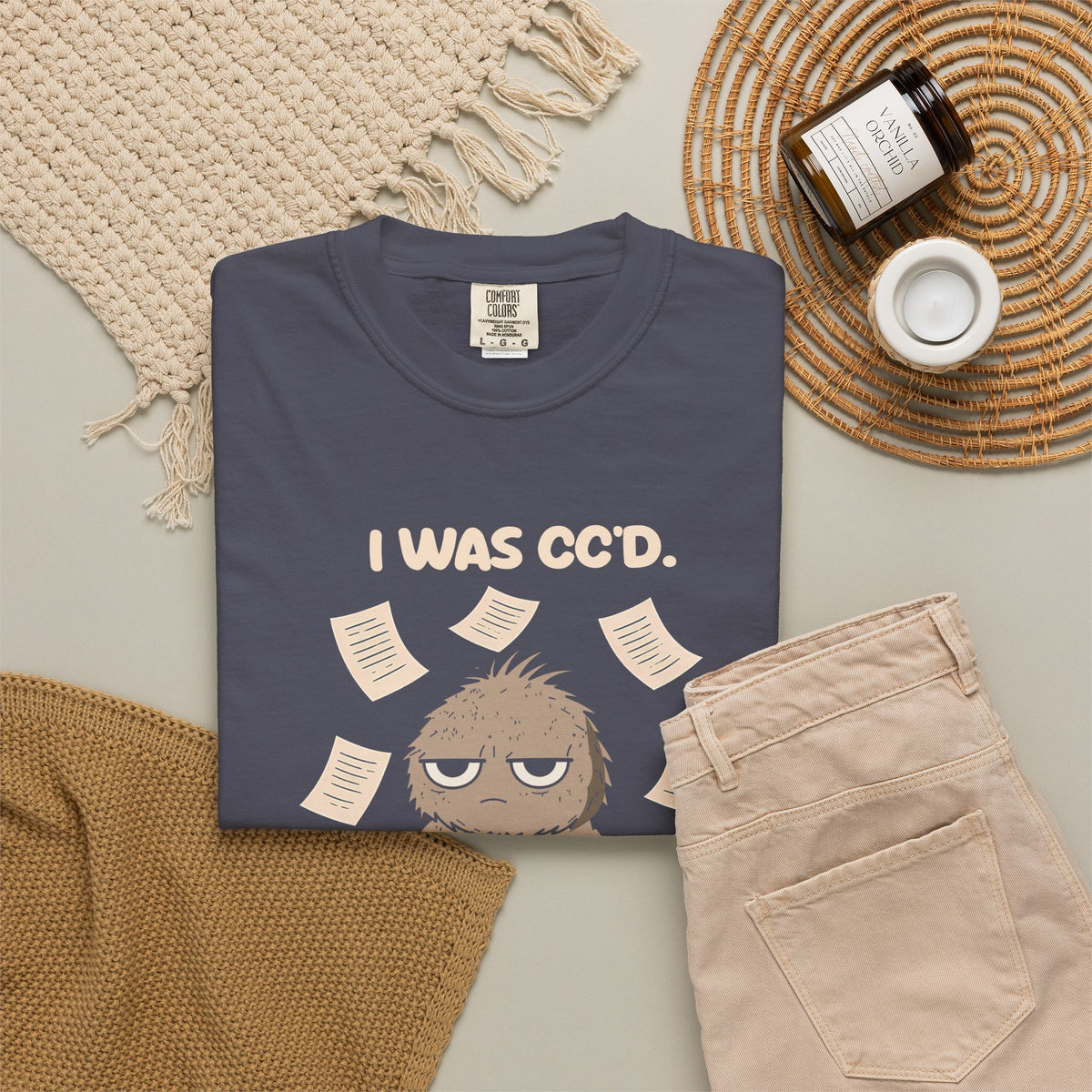 Navy I Was CC'd Murray tee by Mildly Unavailable laid flat with folded pants and home decor