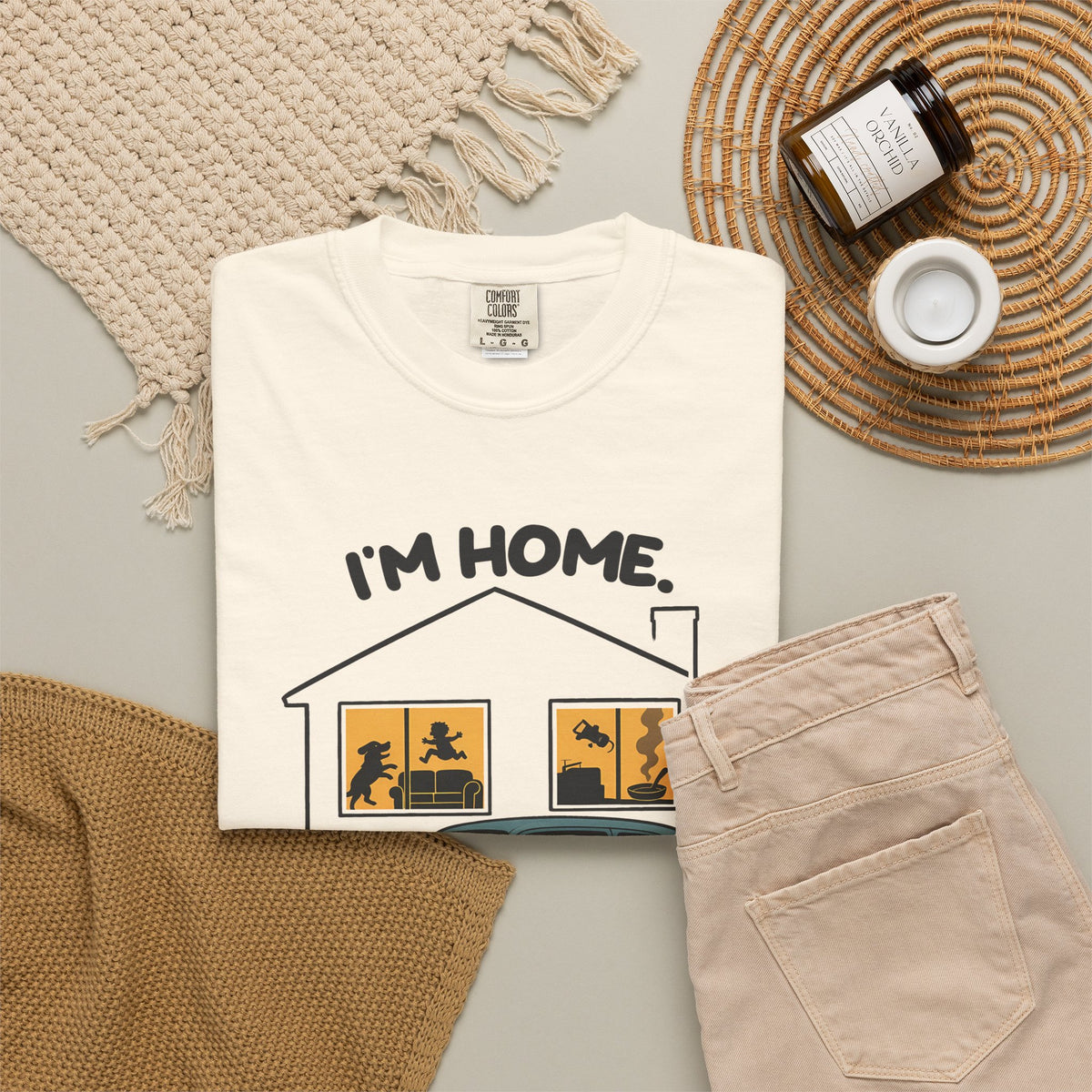 Ivory Just Sitting in the Car for a Minute Murray tee by Mildly Unavailable laid flat with folded pants and home decor